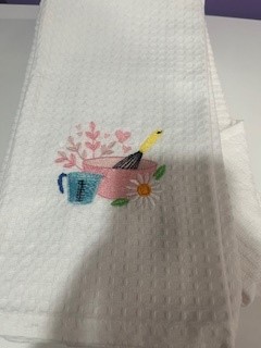 Towel with bowl, whisk and measuring cup.